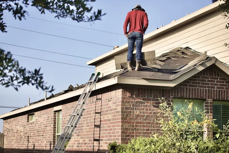 Professional roofer working on a residential roof in Brand Park